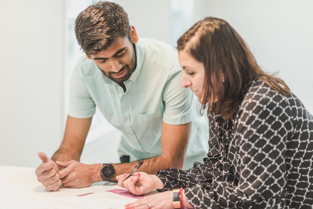 Imagen actual: A real estate agent assists a client with home buying paperwork indoors.