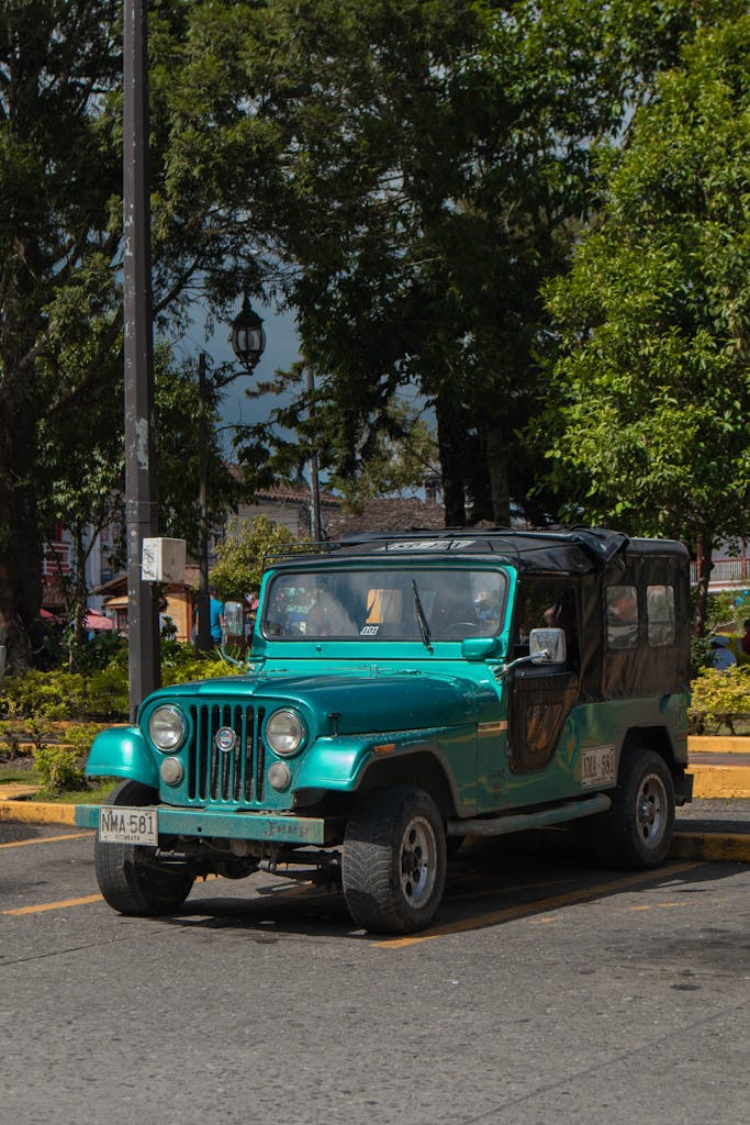 Imagen actual: A classic teal jeep parked under the sun in Filandia, Quindío, Colombia.