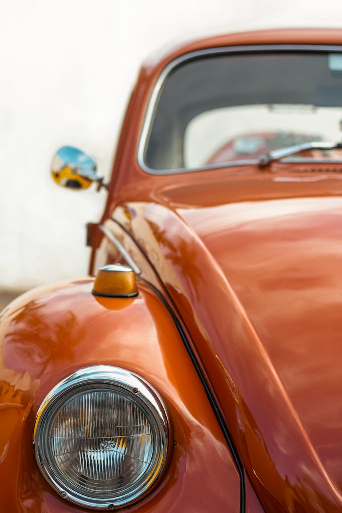 Imagen actual: Close-up of a classic orange Volkswagen Beetle car with chrome details, perfect for vintage auto enthusiasts.