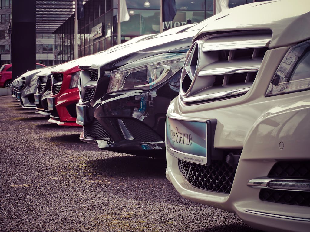 Imagen actual: Luxury cars lined up at an outdoor dealership, showcasing sleek designs.