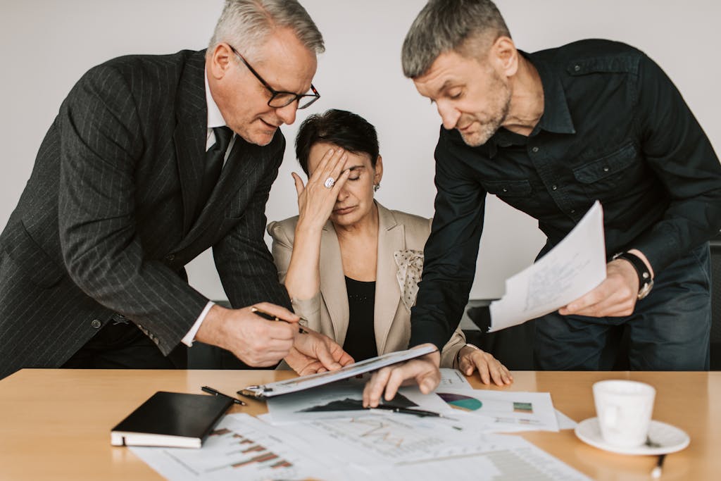 Imagen actual: A professional team in a tense business meeting discussing financial documents.